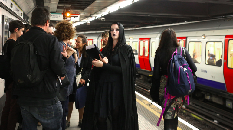 Girl dressed in black goth clothing on a busy tube platform