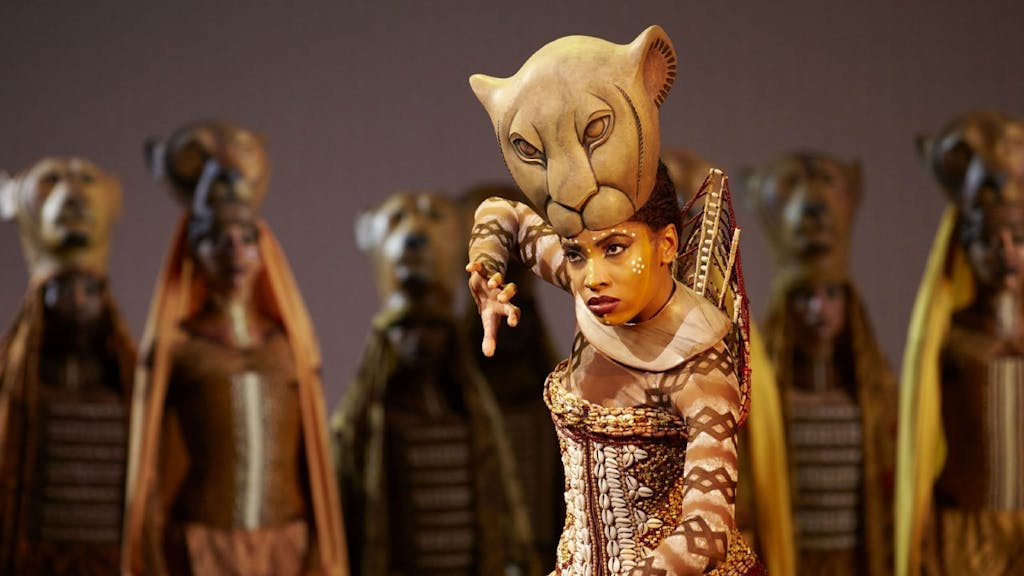 The Lion King actors in costume, with one in the foreground