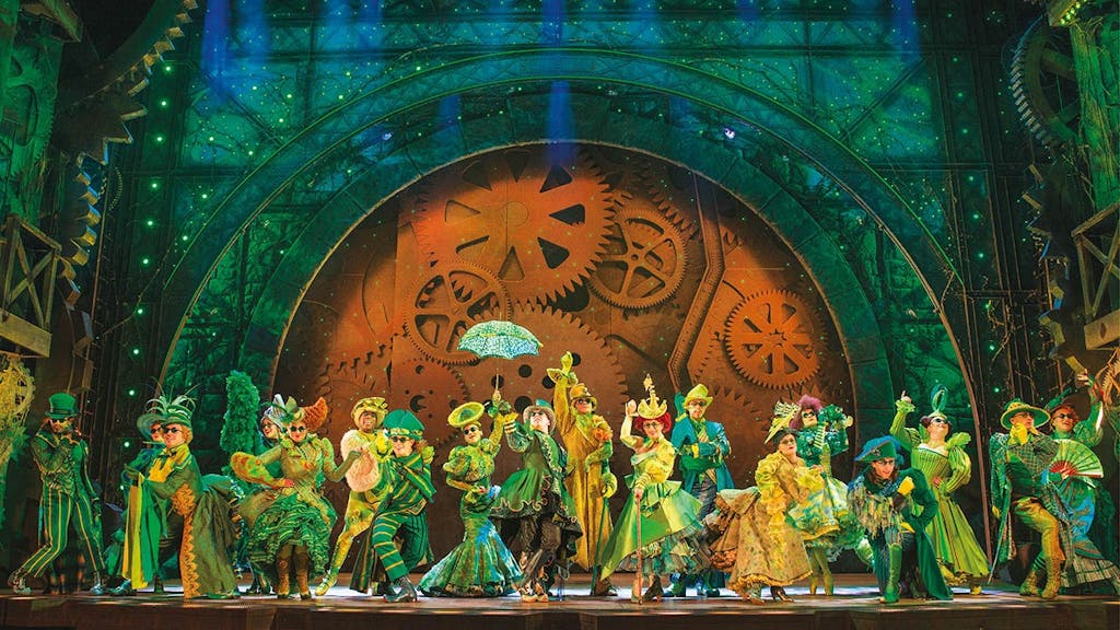 photo of wicked ensemble members onstage in green costumes