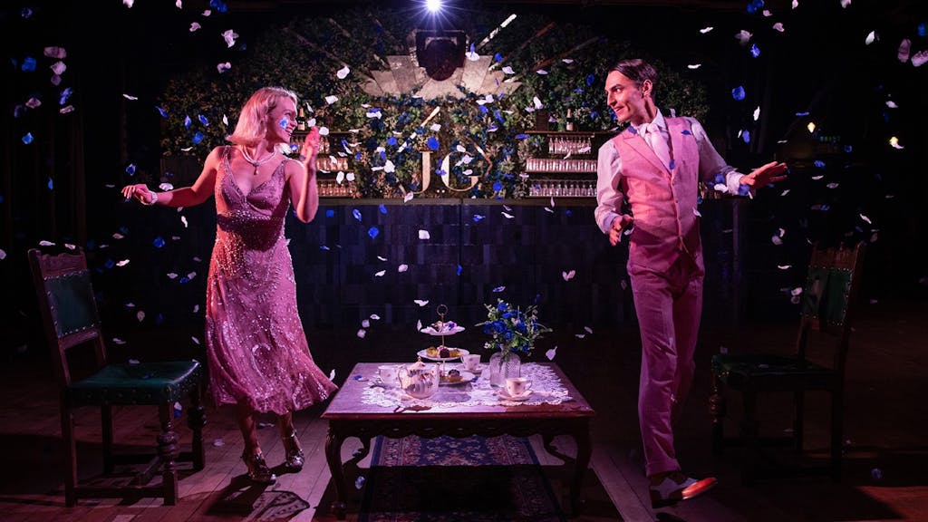 Daisy and Gatsby from The Great Gatsby dancing on opposite sides of a table and looking at each other