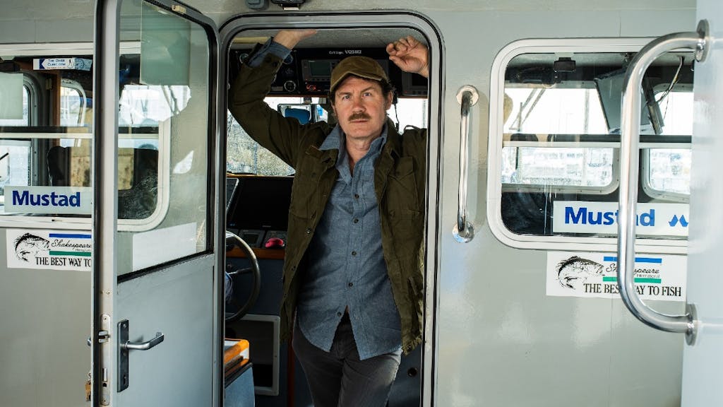 Ian Shaw of The Shark is Broken stands in a vehicle doorway